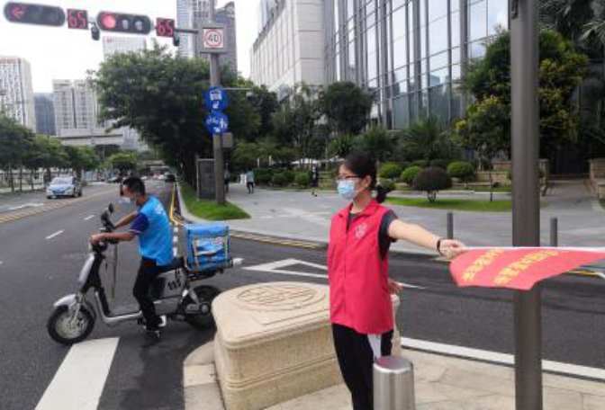 志愿者走上街頭擺放亂停的共享單車,進行交通文明勸導.png